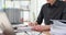 Woman hand holds pen and writes notes on financial report with workplace schedule