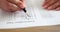 Woman hand holds pencil and marks answers to test