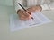 Woman hand holds pencil and marks answers to test in exam