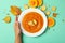 Woman hand holds plate of pumpkin soup