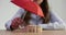 Woman hand holds red umbrella and covers wooden crowd of employees