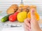 Woman hand holds the thumb up. Cookies are in the cage locked with padlock. Vegetables, fruits and measuring tape with centimeters