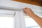 Woman hand insulating old windows to prevent warmth heat leak and drafts, preparing house for winter and cold weather