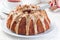 Woman hand with knife cut the sweet potato pecan pound cake with caramel icing, horizontal