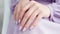 Woman hand with lavender color nail polish on her fingernails. Purple nail manicure with gel polish at luxury beauty salon. Nail