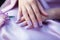 Woman hand with lavender color nail polish on her fingernails. Purple nail manicure with gel polish at luxury beauty salon. Nail