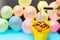 Woman hand lighting up candle. Hand lights birthday candle cupcake.Colorful balloons on the background.Birthday concept