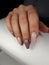 Woman hand with manicured nails beige colour on the black and white background