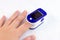 Woman hand with medical fingertip pulse oximeter tool for oxygen saturation check during covid virus desease. SpO2 monitoring