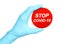 Woman hand in medical gloves holds red sign Stop Covid-19