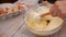 Woman hand mix the egg-white whip with other sponge-cake ingredients in a glass bowl