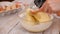 Woman hand mix the sponge-cake ingredients in a glass bowl with a wooden spoon