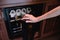 Woman hand open storing bottles of wine in fridge. Cooling and preserving wine