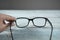 Woman hand optical glasses on table