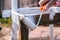 Woman hand with paint roller painting chair outside