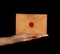 Woman hand palm shows old envelope over black