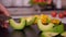 Woman hand peel avocado slices - slow motion