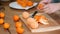 Woman hand peeling ripe sweet tangerine, close up.