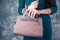 woman hand phone on bag pocket on gray background.