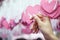 Woman Hand pick pink heart shape Lucky Draw attached to white ribbon on wishing tree in charity event. Games, that prizes are