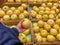 Woman hand picking fresh yellowish pear at grocery store
