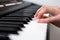 Woman hand playing a MIDI controller keyboard synthesizer close up