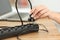 Woman hand plugging electric plug a in a socket