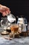 Woman hand pouring coconut cream into Vietnamese drip coffee in glass on wood slab on dark background