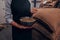 Woman hand pouring fragrant coffee beans on a pile of roasted Arabica grains on a bawl with coffee bawl. Selection of fresh coffee