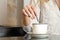 Woman hand preparing a cup of coffee