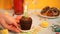 Woman hand put a delicious chocolate muffin cupcake with Birthday candle on the table with other sweets and candies