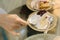 Woman hand put pudding on the cake crust