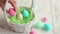 Woman hand puts decorated eggs into handmade wicker basket with paper filler happy easter concept