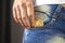 Woman hand putting bitcoin in jeans pocket, golden cryptocurrency coin in pocket background photo