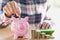 Woman hand putting coin into piggy bank. Saving money wealth and