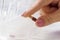 Woman hand putting pills into open pill organizer or plastic pillbox