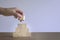 Woman hand putting a square wood block on pyramid stack of wood blocks