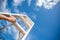 Woman Hand Reaching For Red Ladder Leading To A Blue Sky