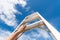 Woman Hand Reaching For Red Ladder Leading To A Blue Sky step