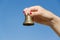 Woman hand red nails hold iron bell on blue sky