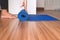 Woman hand rolling or folding blue yoga mat after a workout,Exercise equipment Healthy fitness and sport concept