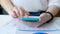 Woman hand with smartphone, business charts on a table, close up