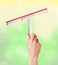 Woman hand with special squeegee for cleaning over bright