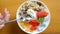 Woman hand with spoon eat bowl of homemade granola with yogurt and fresh berries