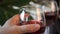 Woman hand take a glass with red grape wine. Bottle on the background. Romantic dinner concept.