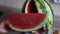 Woman hand takes a piece of watermelon. Concept summer ripe berry on a wooden board.