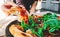 Woman Hand takes a slice of meat neapolitan Pizza with Mozzarella cheese, ham, bacon, tomato, Spices and jalapeno