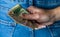 Woman hand taking money from jeans back pocket. Woman hiding money behind her back. Dollar banknotes close up