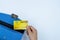 Woman hand taking out the credit card from blue purse for payment on the white background. Finance and money concept, top view,