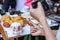 Woman hand is taking picture mini heart with bread on the table